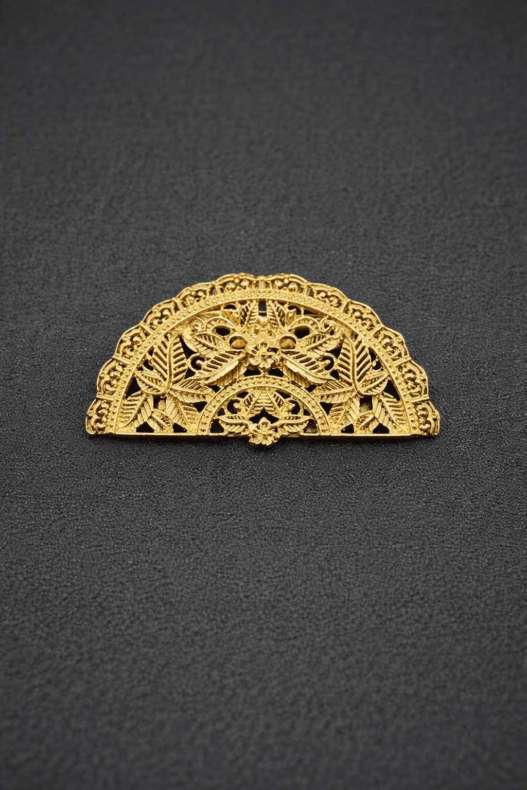 Gold lace hair clip on a black background