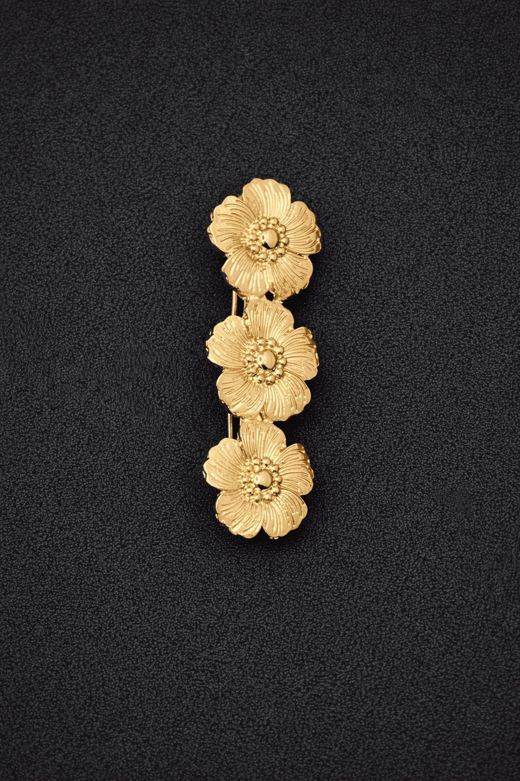 Gold floral pendant on a black background