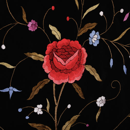 Embroidered floral design with a red rose on a black background