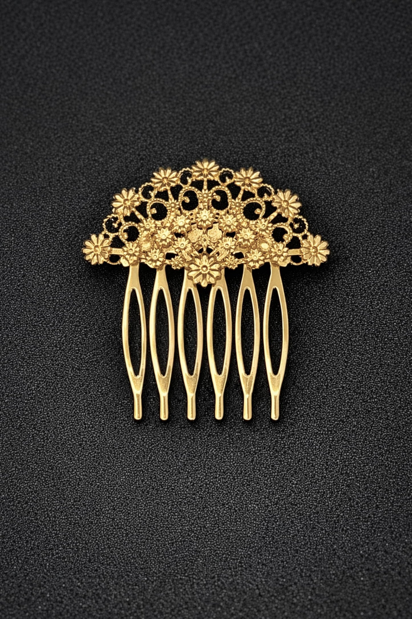 Gold hair comb with floral design on a black background