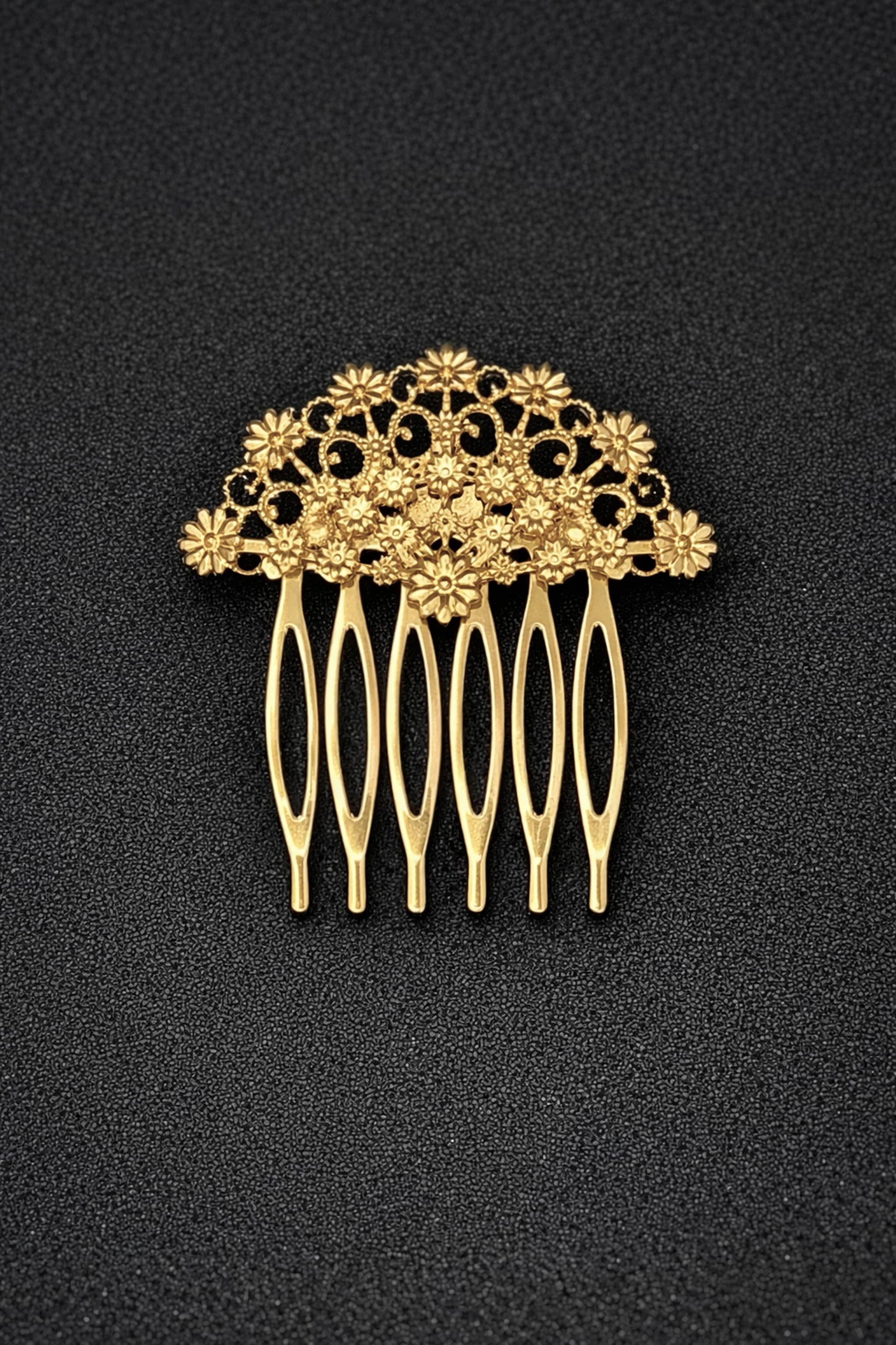 Gold hair comb with floral design on a black background