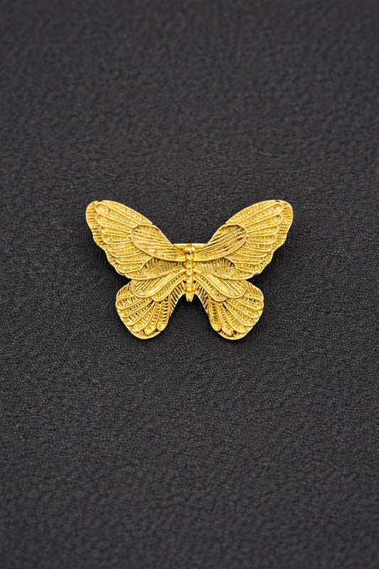 Gold butterfly-shaped object on a black textured background