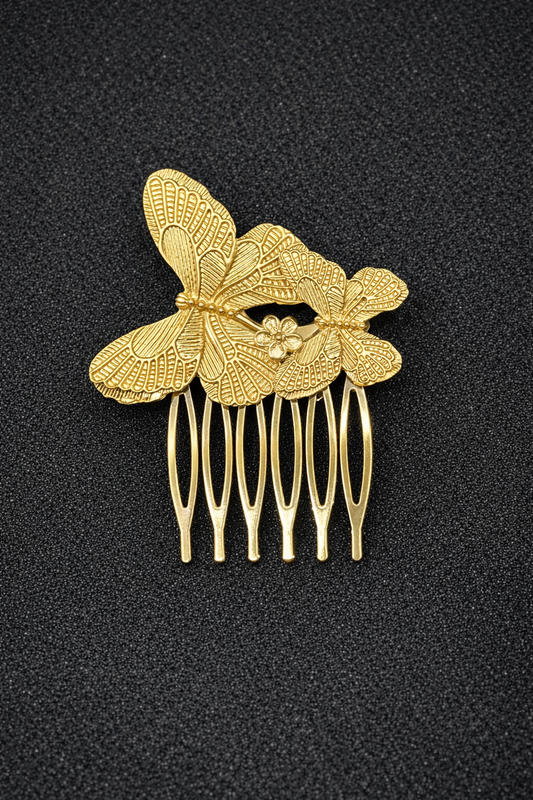 Gold hair comb with decorative butterfly design on a black background