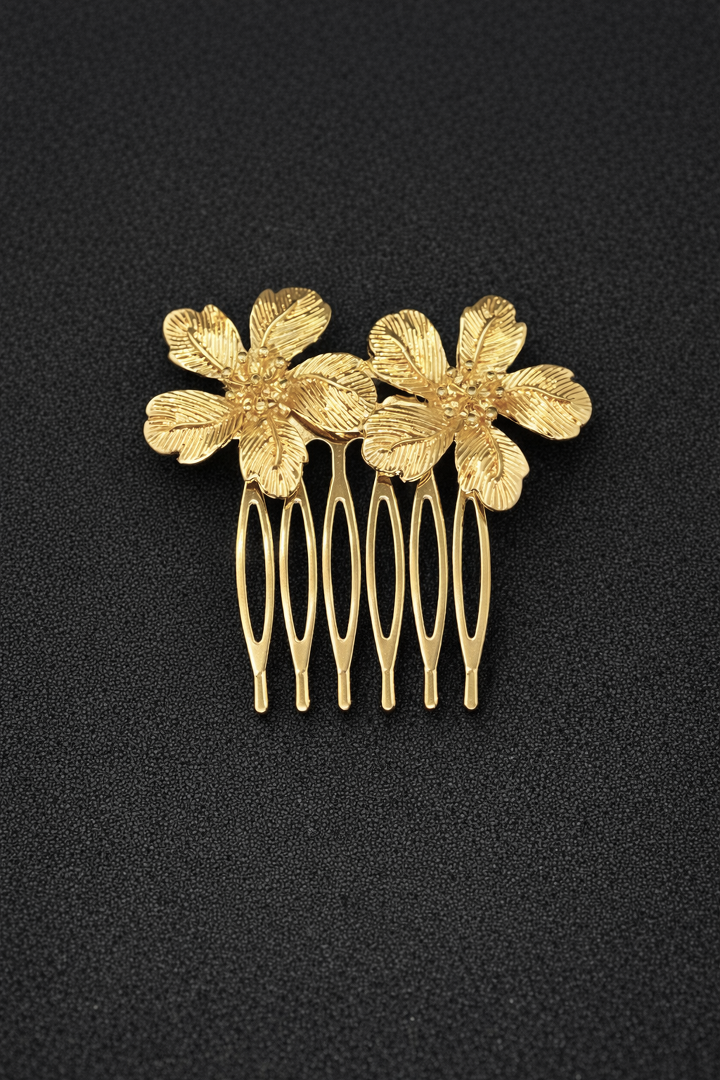 Gold hair comb with floral designs on a black background