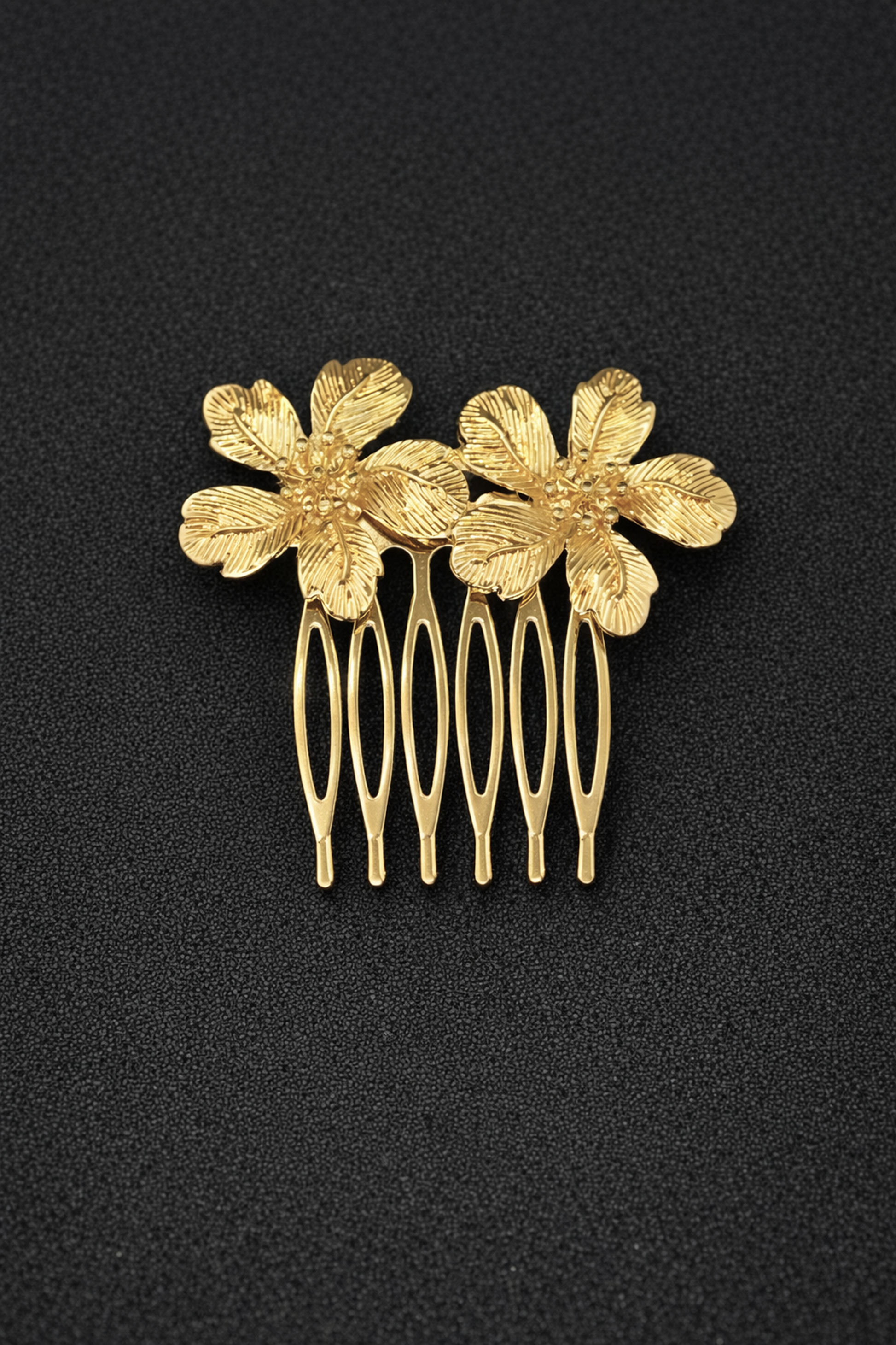 Gold hair comb with floral designs on a black background