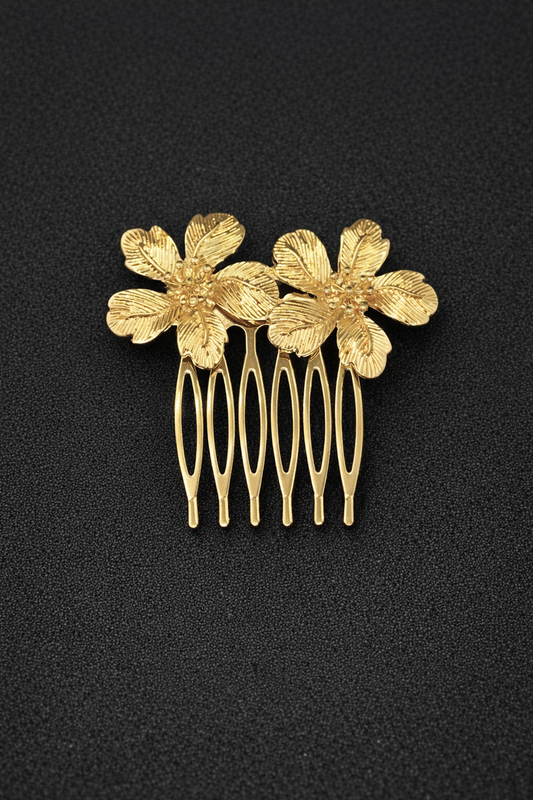 Gold hair comb with floral designs on a black background