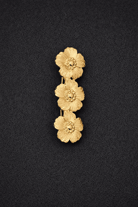 Gold floral pendant on a black background
