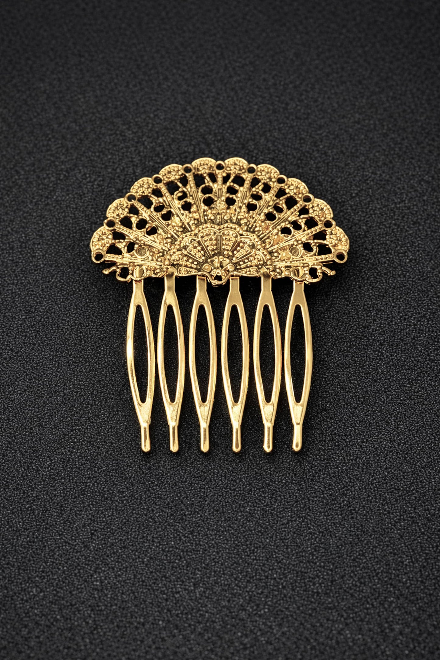 Gold hair comb with intricate design on a black background