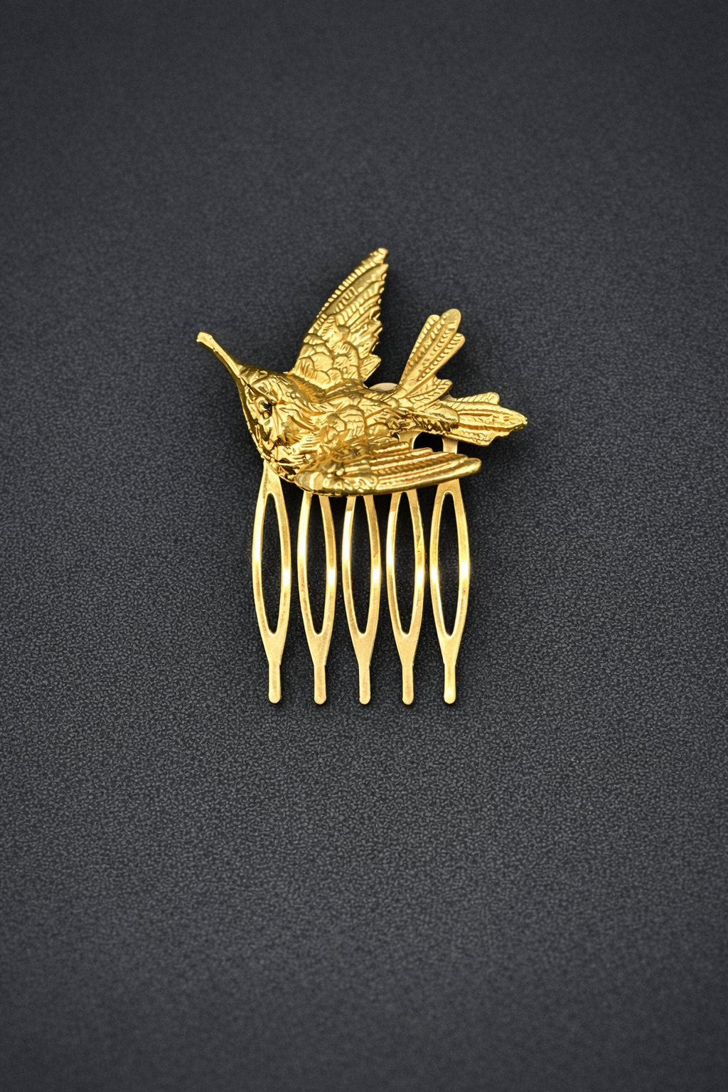 Gold hummingbird comb on a black background