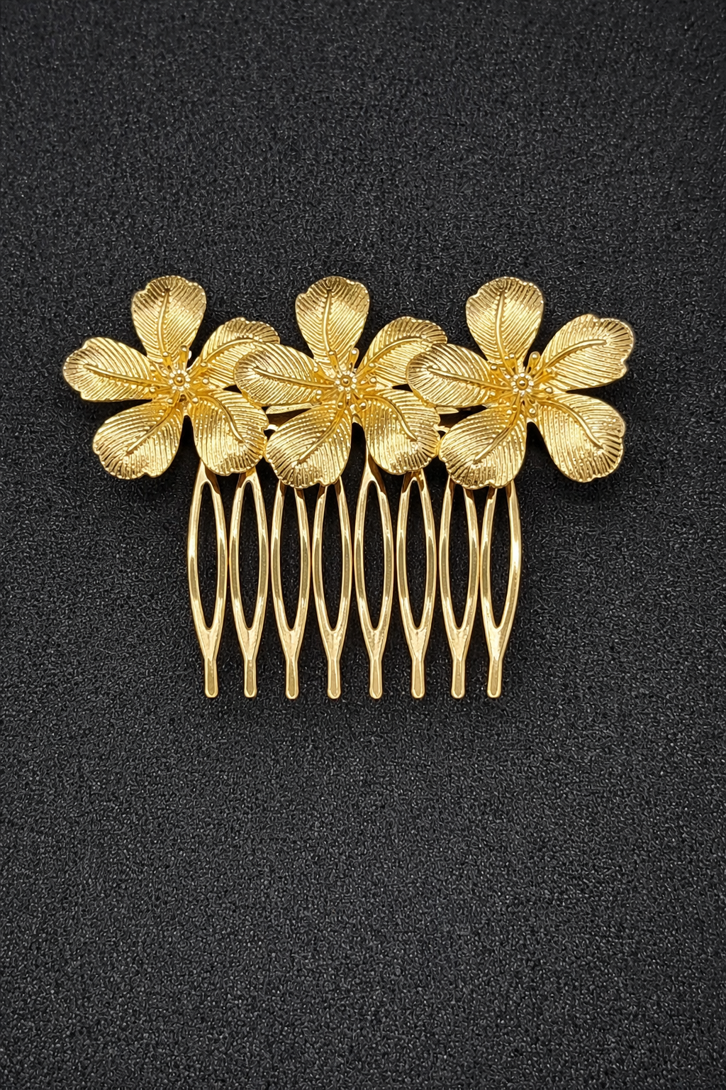 Gold floral hair comb on a black background