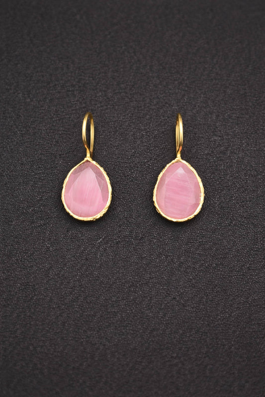 Pair of pink teardrop earrings with gold hooks on a dark textured background